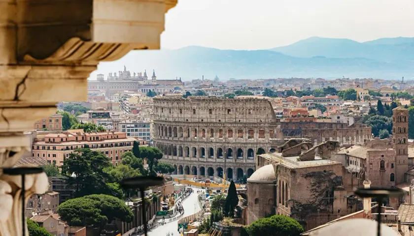 Vista panoramica di Roma con il Colosseo in primo piano, perfetta per un weekend in metro tra storia e bellezza.