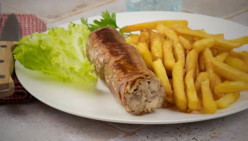 Une belle andouillette grillée avec des frites croustillantes et une feuille de laitue fraîche. Un plat simple et savoureux.