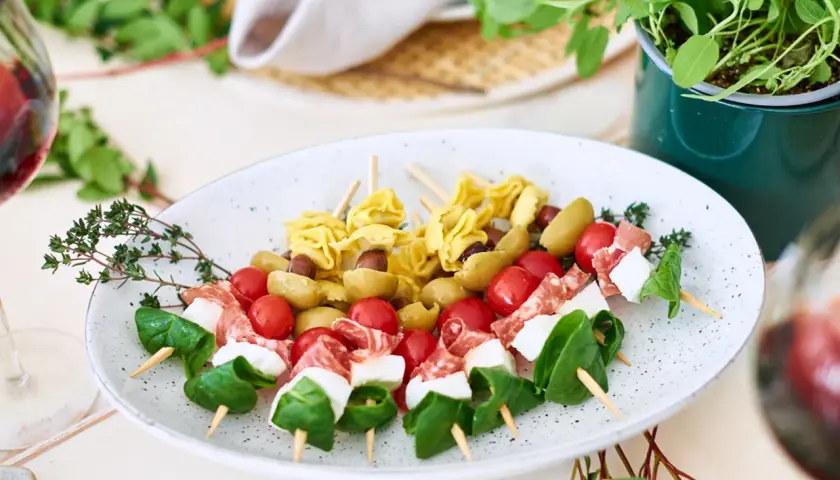 Köstliches italienisches Fingerfood auf Spießen: Tortellini, Oliven, Kirschtomaten, Mozzarella und Salami. Perfekt für jede Party!