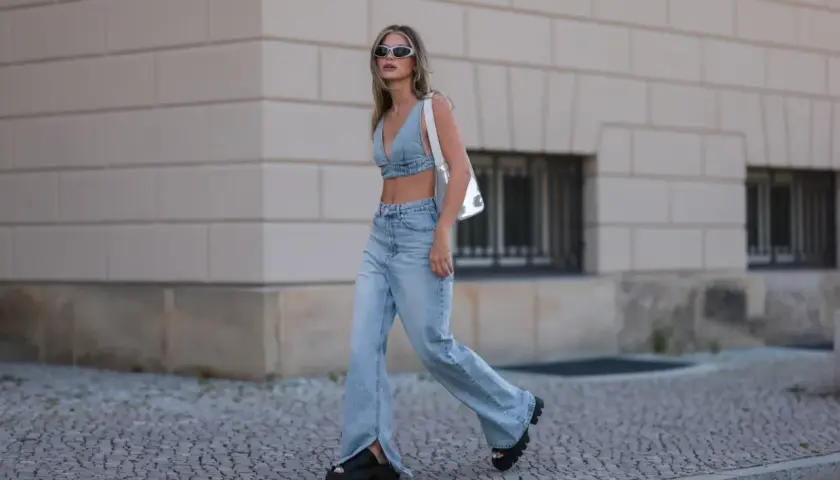 Stylowa kobieta w jeansach bootcut z rozcięciami i denimowym topie, prezentująca letnią modę.