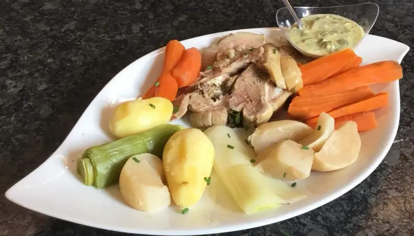 Plat de tête de veau, carottes, pommes de terre et poireaux, servi avec une sauce tartare. Une recette traditionnelle pour un repas réconfortant.