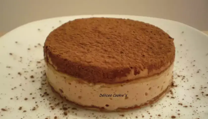 Un délicieux tiramisu tofu soyeux, saupoudré de cacao, sur une assiette blanche.