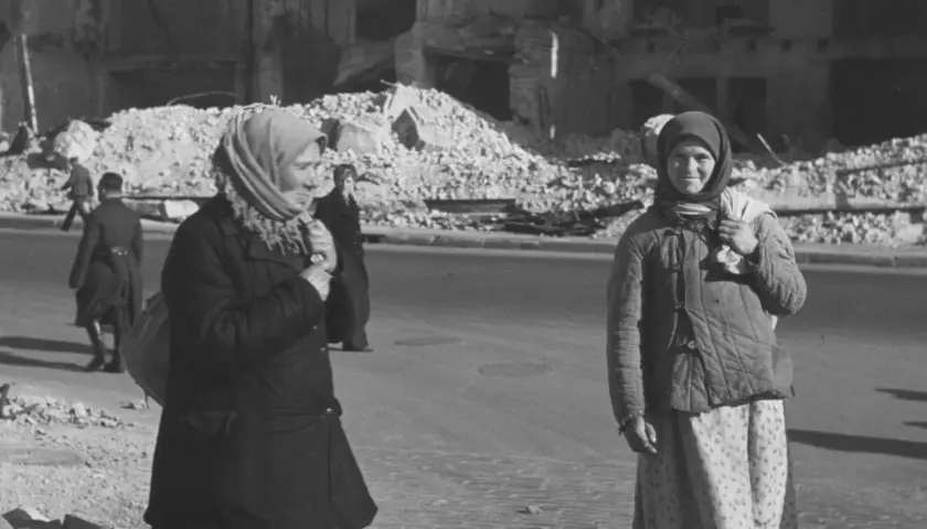 Zwei Frauen stehen in Kiew 1941 vor Trümmern. Die eine trägt einen Schal, die andere eine Steppjacke.