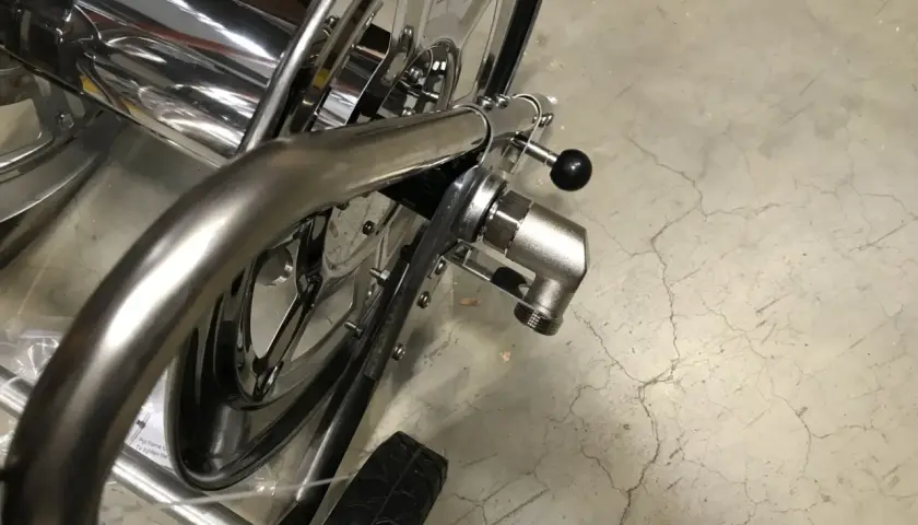 Hochglänzender schlauchwagen edelstahl mit schwarzem Griff und Rad. Perfekt für Garten und Werkstatt.