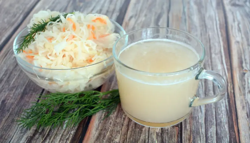 Szklanka z sokiem z kiszonej kapusty i miska z samą kapustą, idealne na dietę.