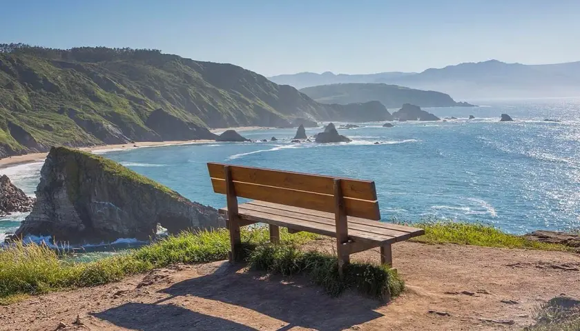 Un banco de madera invita a contemplar el mar azul y las verdes colinas. Podría ser el banco mas bonito del mundo en Vigo.