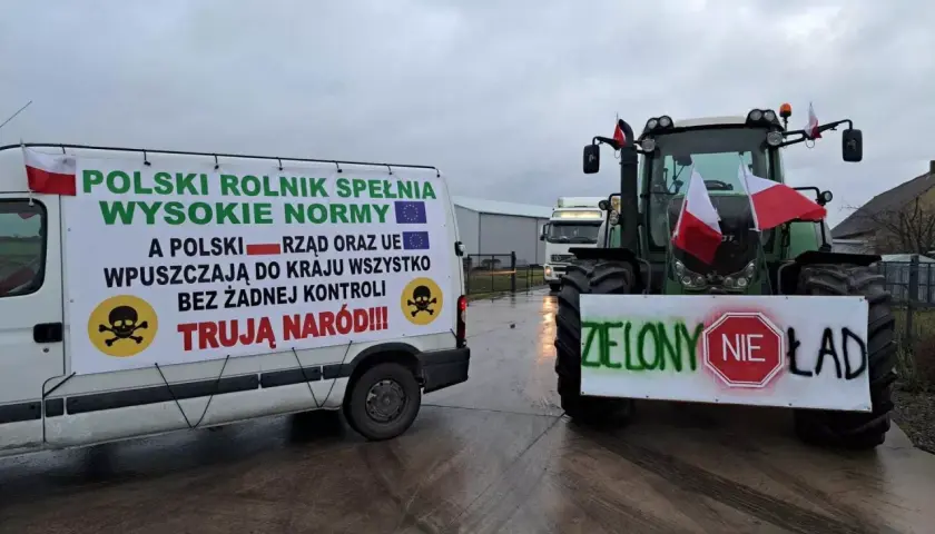 Ciężarówka i traktor z polskimi flagami i transparentami protestacyjnymi.
