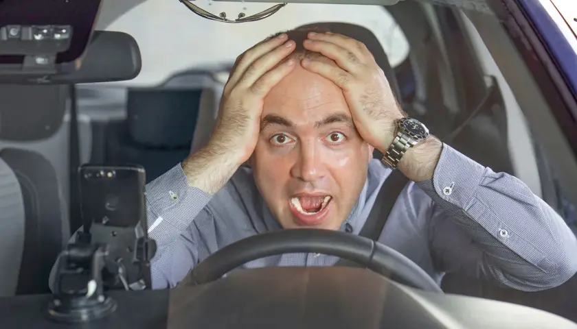 Uomo disperato al volante, mani sulla testa, con un'espressione di panico. Forse si può avere un'anomalia al differenziale.