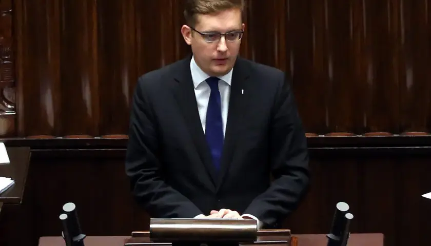 Młody działacz Ruchu Narodowego, w garniturze i z niebieskim krawatem, przemawia w Sejmie. Czy to on zostanie nową twarzą partii?