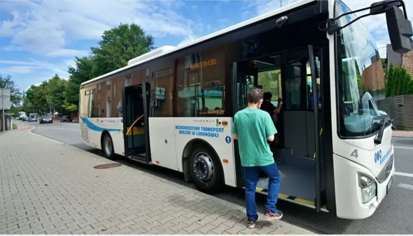Autobus miejski z otwartymi drzwiami, wsiada pasażer.