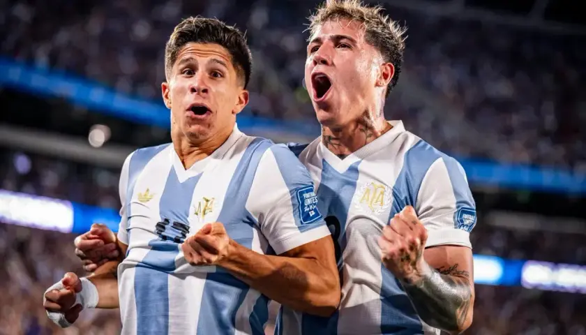 Dwóch piłkarzy Argentyny w biało-niebieskich koszulkach świętuje zwycięstwo nad Brazylią.