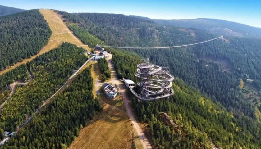 Widok na Sky Walk i najdłuższy most wiszący na świecie, otoczone gęstym lasem i górskimi zboczami.