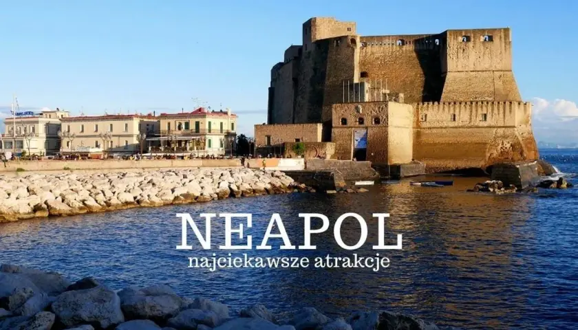 Zamek Castel dell'Ovo w Neapolu nad wodą, z budynkami w tle.
