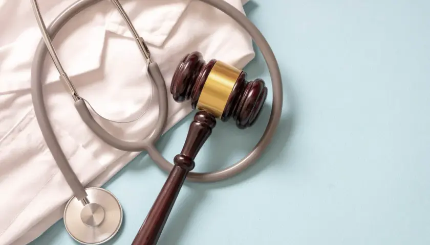 Martelletto da giudice e camice bianco con stetoscopio. Simboleggia la giustizia medica e la diagnosi sbagliata tumore.