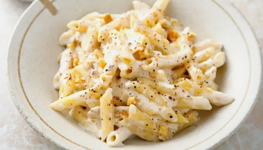 Penne w kremowym sosie z orzechami włoskimi, posypane pieprzem. Pyszne danie, które zachwyci każdego smakosza.