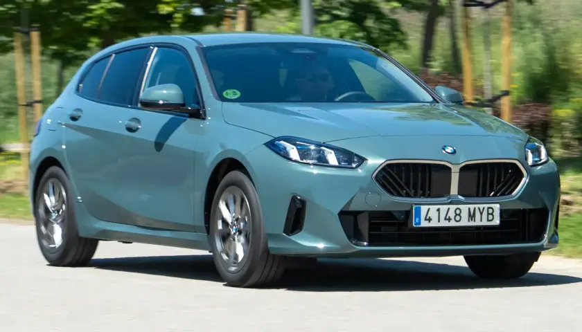 Un BMW Serie 1 gris circula por una carretera. El motor BMW 1.5 3 cilindros es eficiente, pero algunos usuarios reportan problemas.