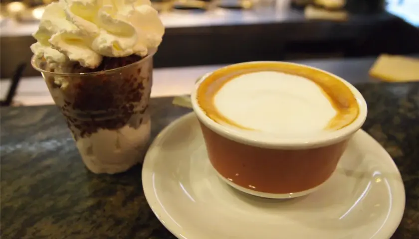 Deser z bitą śmietaną i kawa latte, jakby zrobione z tazza d'oro.