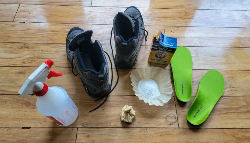 Gather supplies to learn how to clean hiking boots: boots, spray bottle, baking soda, coffee filter, and insoles.