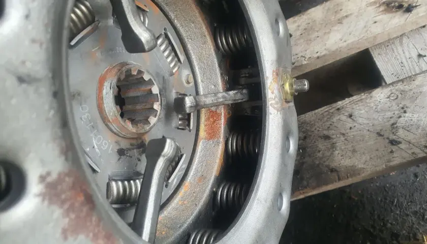Zbliżenie na mechanizm docisku sprzęgła z widocznymi sprężynami i elementami regulacyjnymi.