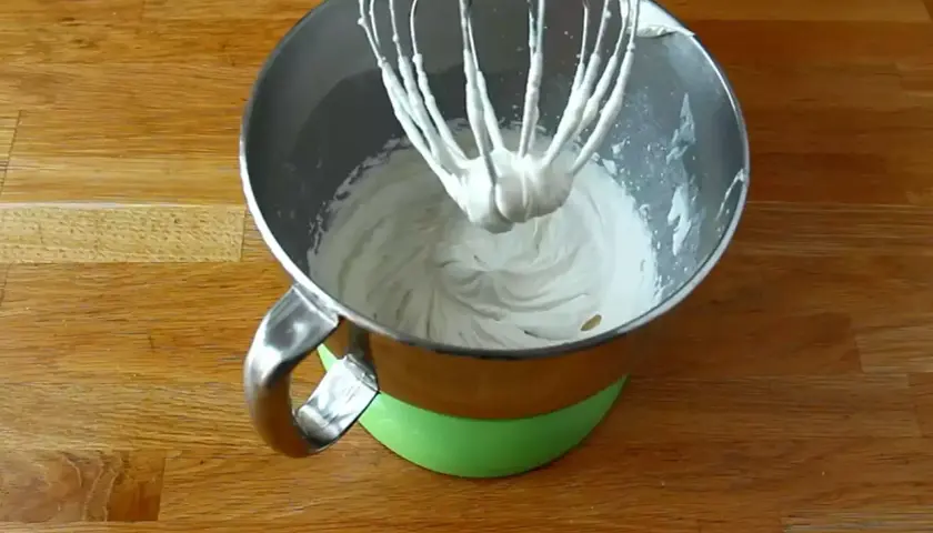 Mieszadło miksera zanurzone w puszystej masie z mascarpone, gotowej do dalszych deserowych przygód.