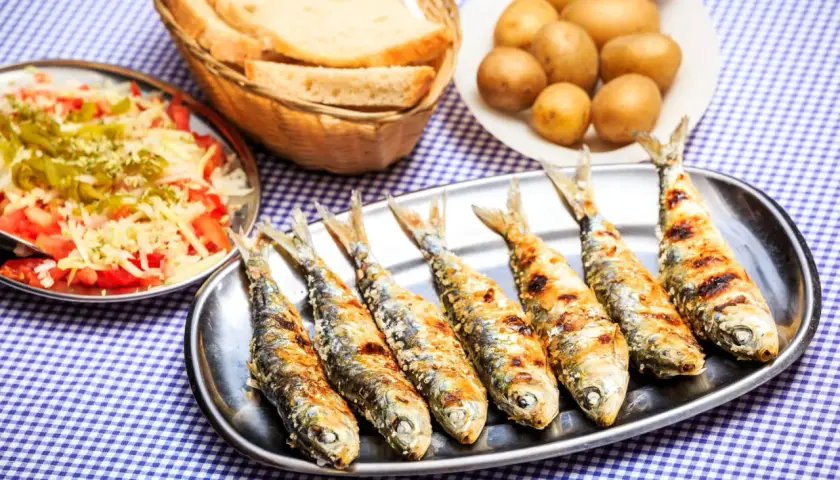 Sardines grillées sur un plateau, accompagnées de pommes de terre, salade et pain. La cuisson des sardines sans odeur est un vrai délice !