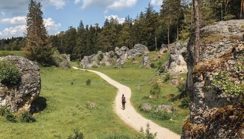 Ein einsamer Wanderer auf einem Pfad durch eine Felsenlandschaft. Ein echter **Geheimtipp Ostdeutschland** für Naturliebhaber.