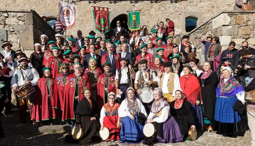 Grupo posa con trajes tradicionales en la fiesta del orujo Potes, algunos portan tambores y panderetas.