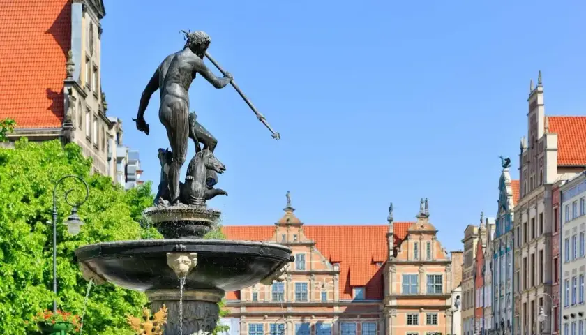Fontanna Neptuna na tle kamienic gdańskiej starówki.