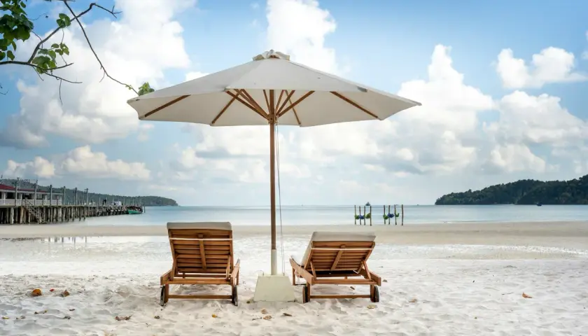 Idealne miejsce, gdzie w czerwcu na wakacje: pusta plaża, leżaki pod parasolem i spokojne morze.