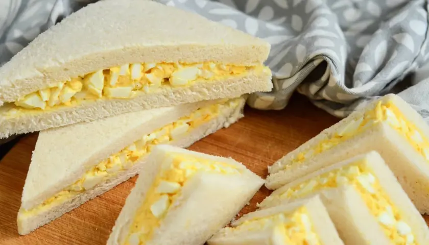 Délicieux tamago sando, des sandwichs au pain de mie blanc et à la garniture crémeuse aux œufs, coupés en triangles.