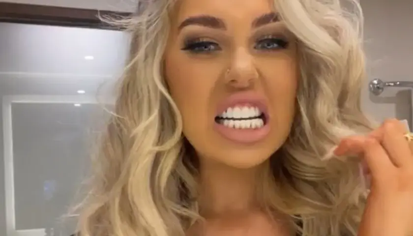 Kobieta z blond włosami prezentuje swoje idealne, białe tureckie zęby, uśmiechając się szeroko.