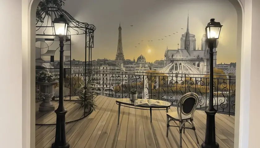 Un balcon parisien avec vue sur la Tour Eiffel et Notre-Dame, un chef-d'œuvre de trompe l'oeil.