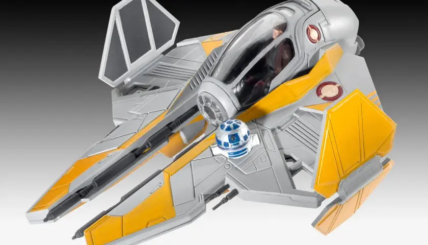 Model statku kosmicznego star wars starfighter w kolorze szaro-żółtym, z droidem R2-D2 na pokładzie.
