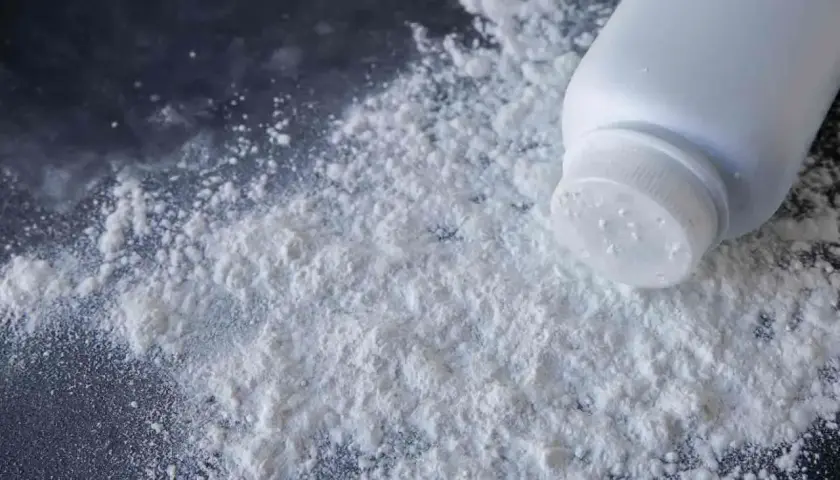 Un flacone di borotalco rovesciato su una superficie scura, creando una nuvola bianca. Forse le formiche lo evitano.