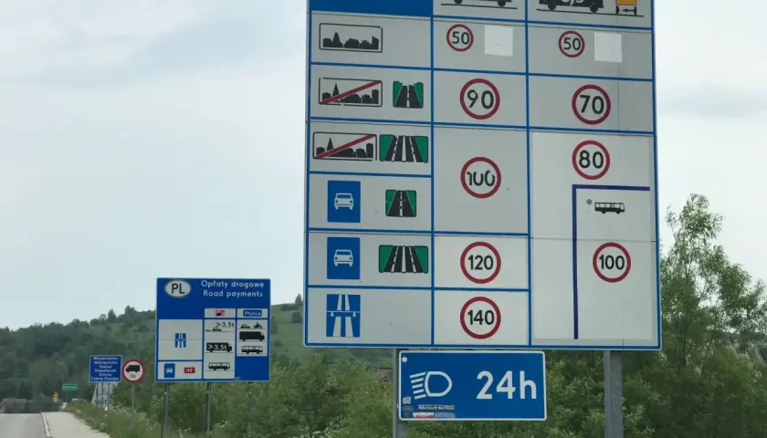 Znaki drogowe informują, ile można jechać z przyczepką na autostradzie. Maksymalna prędkość dla pojazdów z przyczepą to 100 km/h.
