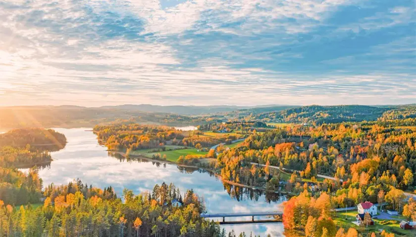 Herbstliche Landschaft in Schweden mit einem See, bunten Wäldern und einer Brücke. Ein Ort, den man gesehen haben muss!