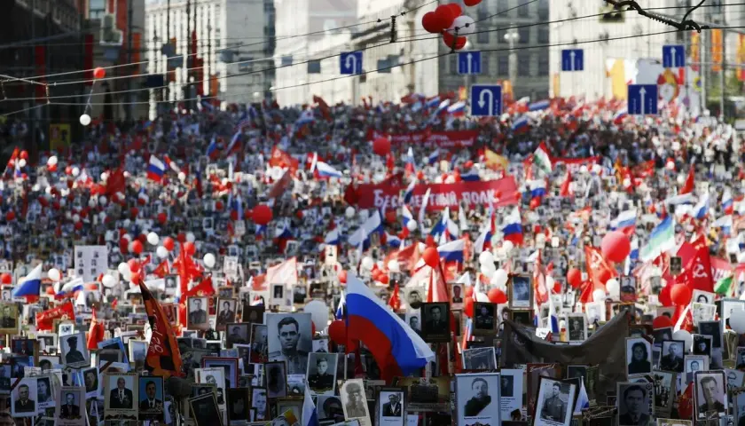 Großer Menschenauflauf mit Fotos und Fahnen in Russland am 8. Mai Feiertag.