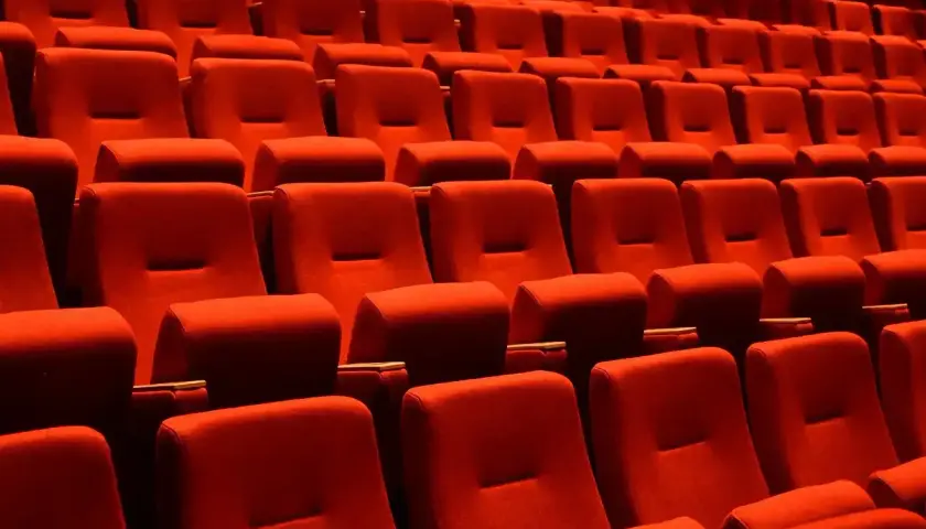 Puste czerwone fotele kinowe czekają na widzów. Czas na przerwę w teatrze, by napić się czegoś lub porozmawiać.