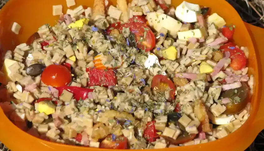 Salade de crozets au thon, garnie de tomates cerises, œufs durs, jambon et herbes. Un plat coloré et savoureux.