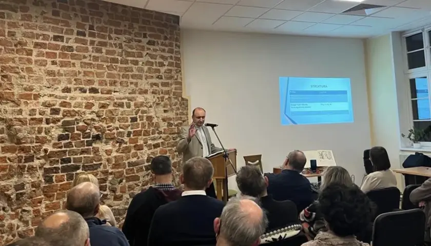 Prelegent omawia strukturę prezentacji, a publiczność słucha, tworząc atmosferę wspólnego zrozumienia i **konkordancji** idei.