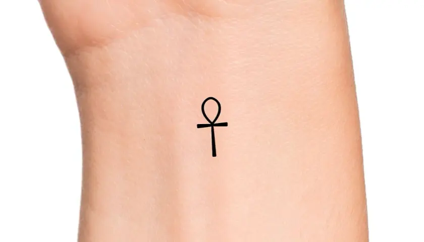 Delikatny ankh tatuaż na nadgarstku, symbol życia i wieczności.