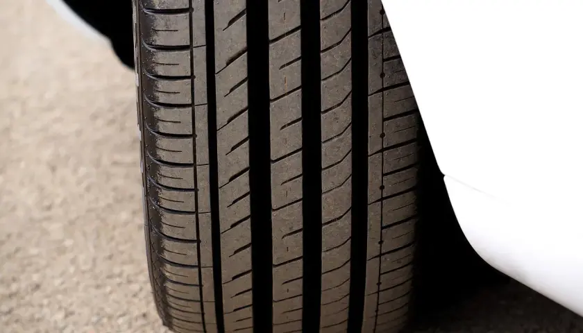 Gros plan sur un pneu 4 saisons, prêt pour le test. Sa bande de roulement profonde promet une bonne adhérence sur toutes les surfaces.