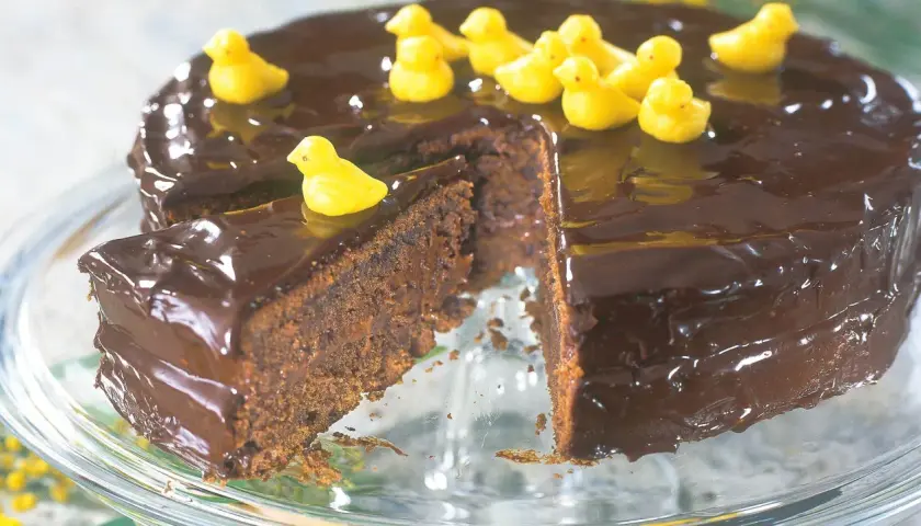 En saftig chokladkaka med blank glasyr, dekorerad med små gula kycklingar. En perfekt påsktårta för alla chokladälskare!