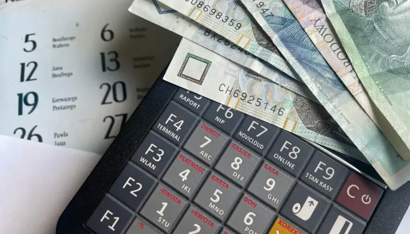 Kalkulator, banknoty i kalendarz. Planowanie wydatków na świadczenie urlopowe.