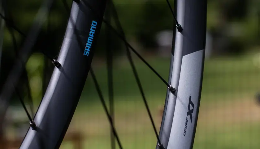 Close-up of two Shimano XT wheelsets, showcasing their durable construction and sleek design, ready for any trail.