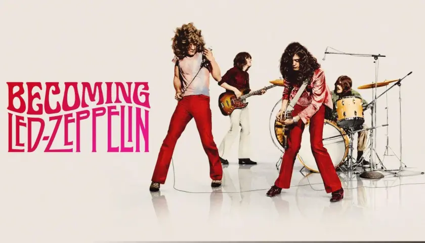 Zespół Led Zeppelin w akcji. Wokalista z mikrofonem, gitarzysta, basista i perkusista tworzą potężne brzmienie.
