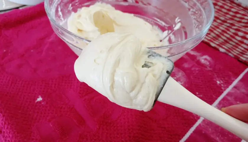 Crème onctueuse de mascarpone sur une spatule, prête pour une délicieuse recette.