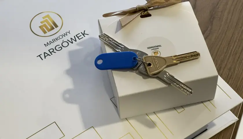 Klucze do nowego mieszkania na Markowym Targówku, zapakowane w eleganckie pudełko z logo.