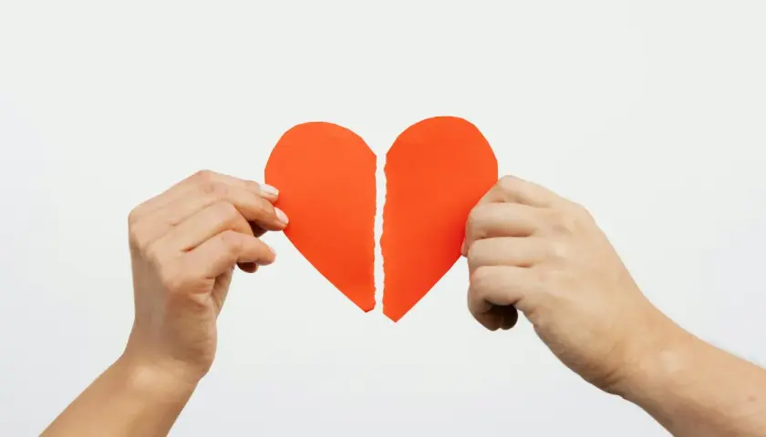 Mani che tengono un cuore rosso spezzato. Ho perdonato un tradimento ma non riesco a dimenticare.