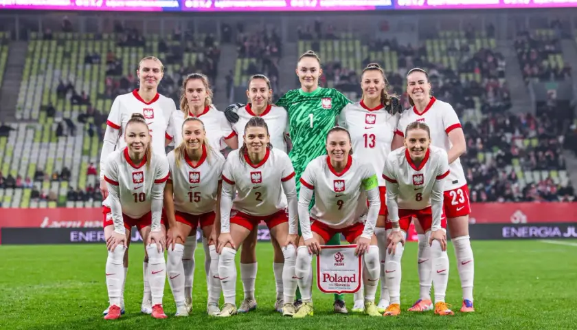 Reprezentacja Polski w piłce nożnej kobiet przed meczem z **Polska Słowenia**. Drużyna w białych strojach z orzełkiem na piersi.
